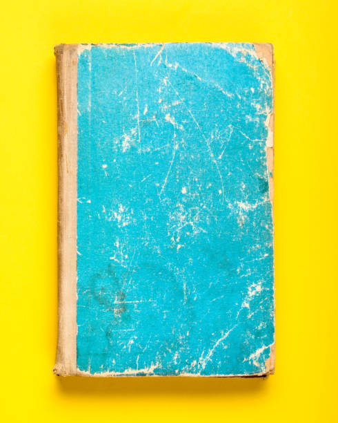 istock Old book with a blue shabby cover on a yellow background 1135376752