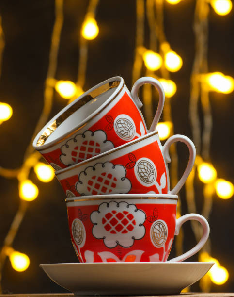 istock Stack of retro ceramic cups on a dark blurred background with light bulbs. 1135377588