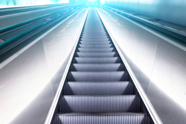 les escaliers escalator montent vers le haut de la lumière bleue de brillance blanche - escalator office vehicle interior built structure photos et images de collection