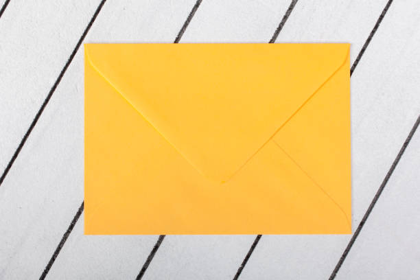 istock yellow envelope on white wooden background 1135380498