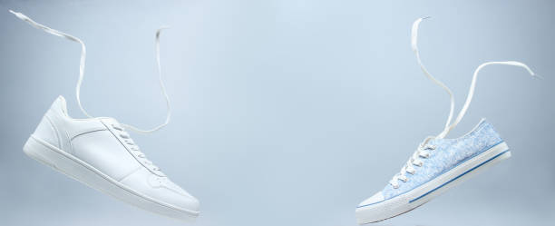 istock White sneakers and floating laces on gray background, minimalism 1135380501