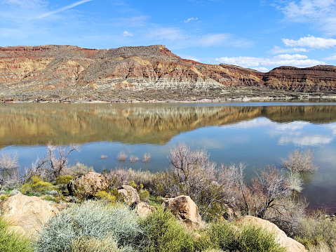 Reflection of red rocks and cliffs at Quail Creek State Park Reservoir near Hurricane Utah
