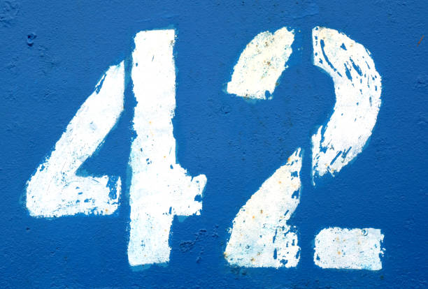 istock Number 42 in stencil on rusty navy blue metal wall. 1135382055