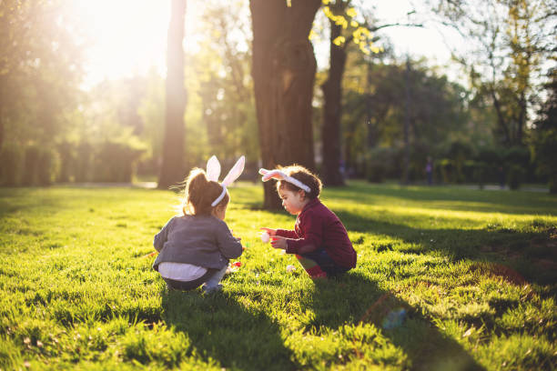 i più piccoli nella caccia alle uova di pasqua - two eggs foto e immagini stock