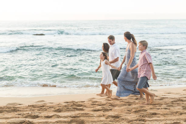istock Family walking together on the beach 1135384268