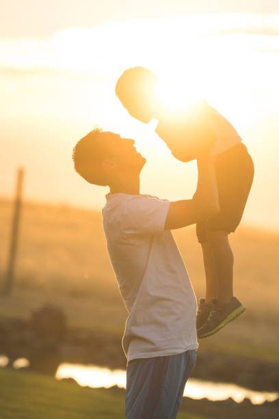 istock Dad holds his son up in the air 1135385089