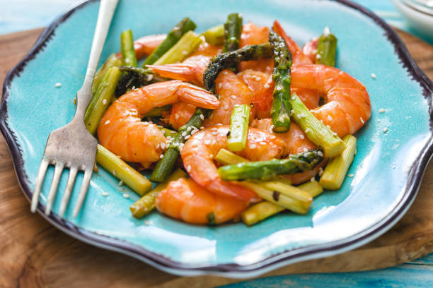 Freshly grilled shrimps with asparagus and sour cream