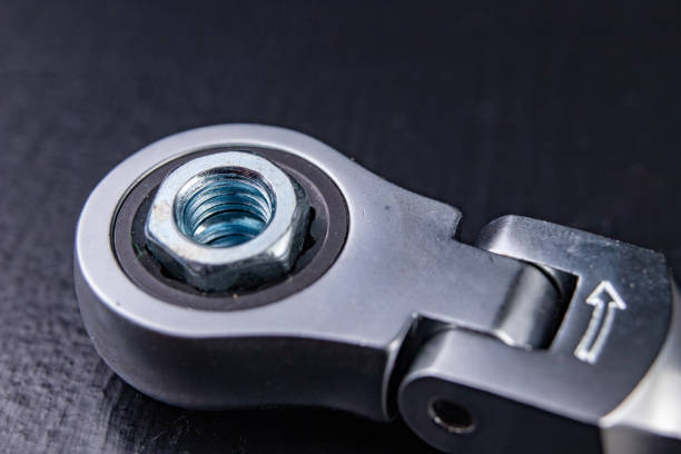 istock New chrome-plated key ring with latch and nut. Accessories for a mechanic on a workshop table. Dark background. 1135385400