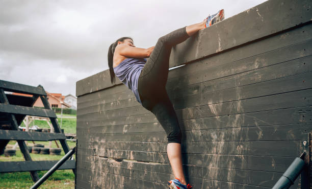 istock Participant in obstacle course climbing wall 1135386634