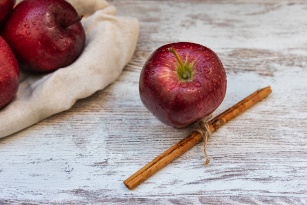 istock Healthy and organic red apple and a stick cinnamon on rustic background 1135386792
