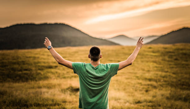 istock Young man celebrating freedom on a field during sunset. 1135386914