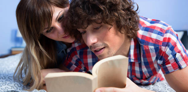 istock Couple reading a book on the bed 1135388431