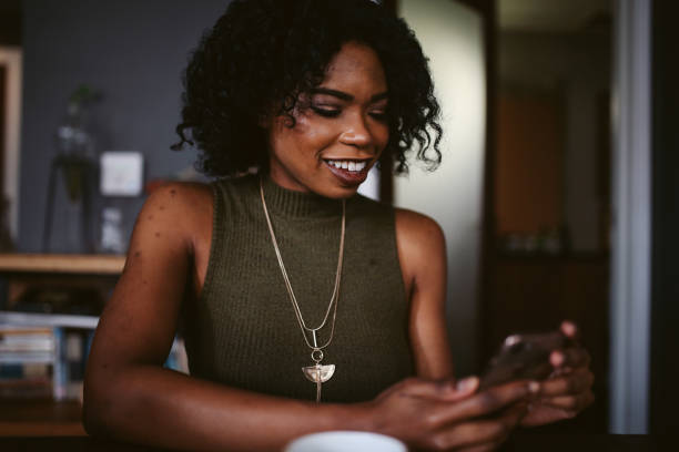 istock Young woman having a coffee in her apartment while browsing the web on tablet 1135390560
