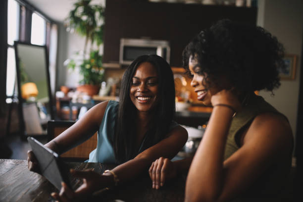 istock Young women at home, watching stuff on tablet together 1135392083