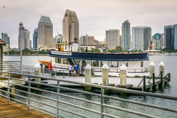 un traghetto si prepara a partire da coronado island verso il centro di san diego visibile sullo sfondo - depart foto e immagini stock