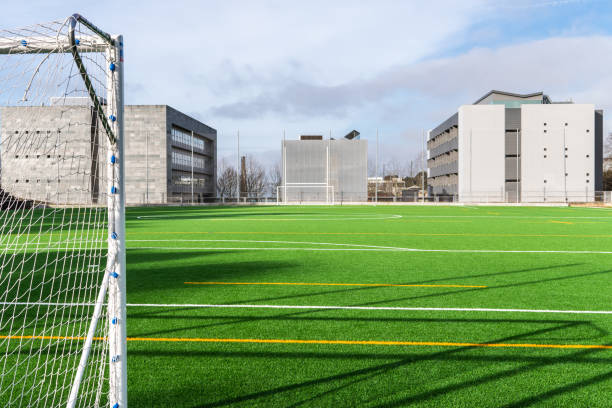 campamento de fútbol con edificios modernos en el fondo - soccer soccer field grass artificial turf fotografías e imágenes de stock