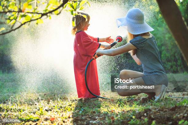 Kleiner Junge Der Mit Seiner Mutter Im Garten Wässert Stockfoto und mehr Bilder von Bewässern