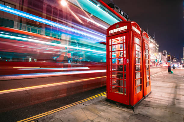 런던의 상징적인 전화 부스 옆에 있는 2 층 버스의 라이트 트레일 - telephone booth 뉴스 사진 이미지