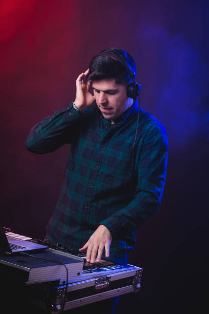 istock Portrait of stylish Deejay playing at Dj mixer on light studio background. 1135396972