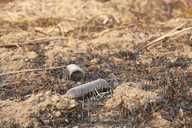 istock An empty glass charred bottle is lying on grass that has been baked out. Ecological catastrophy. Spring tan green cover. Danger of fire. The destruction of life and pollution. Problems of civilization 1135397314