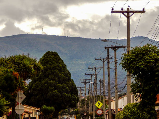 istock Street with electrical poles and trees with mountains in background 1135398345