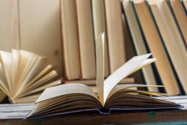 istock Open book, hardback books on wooden table. Back to school. Copy space. 1135399838