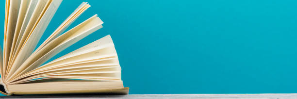 istock Open book, hardback books on wooden table. Back to school. Copy space. 1135399905