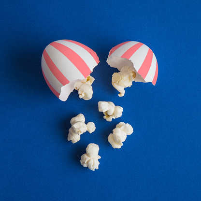 Popcorn out from broken egg minimal food and cinema creative concept.