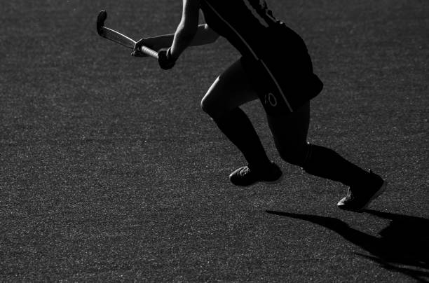 силуэт. тень хоккеиста бежит с хоккейной клюшкой на хоккейном поле - field hockey ball individual sports sports and fitness стоковые фото и изображения