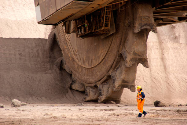 Bucket wheel excavator at work in a quarry One of the world's largest bucket-wheel excavators digging lignite (brown-coal) in of the world's deepest open-pit mines in Hambach on September 1, 2010. The bucket-wheels are capable of moving up to 240,000 cubic meters (8.510 million cubic feet) of earth per day. bagger stock pictures, royalty-free photos & images