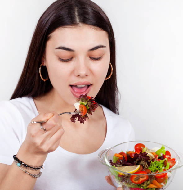 istock beautiful woman eating salad 1135406082