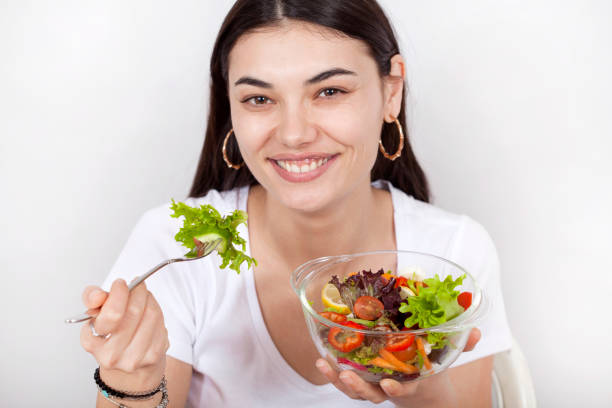 istock beautiful woman eating salad 1135406231