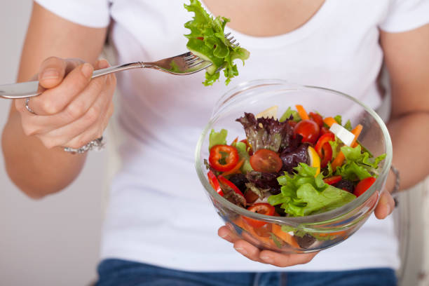istock beautiful woman eating salad 1135406239