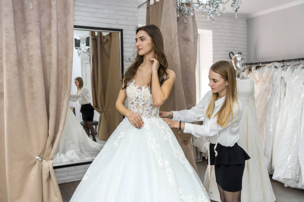 istock Tailor measuring wedding dress on bride in store 1135408096