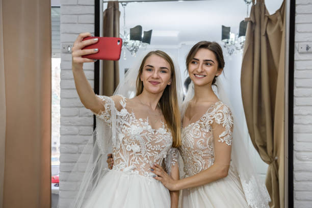 istock Friends in wedding dresses making selfie in salon 1135408140