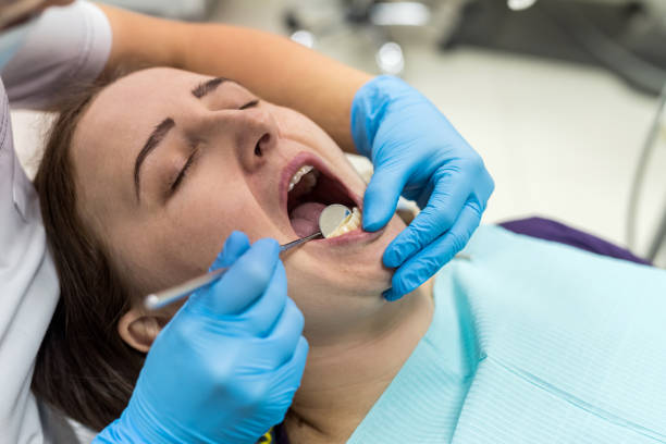 istock Doctor in dentistry examining patient's teeth with mirror 1135408328