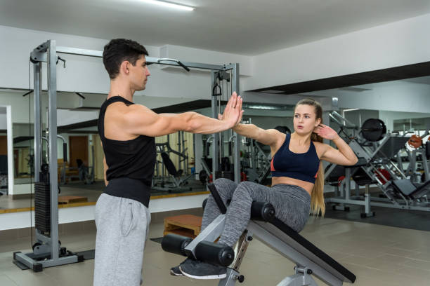 istock Woman training in gym with personal coach 1135408342