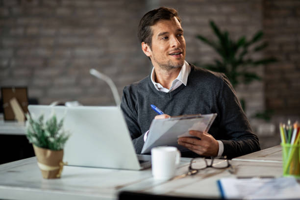 istock Male entrepreneur working on business reports and taking notes in the office. 1135408403