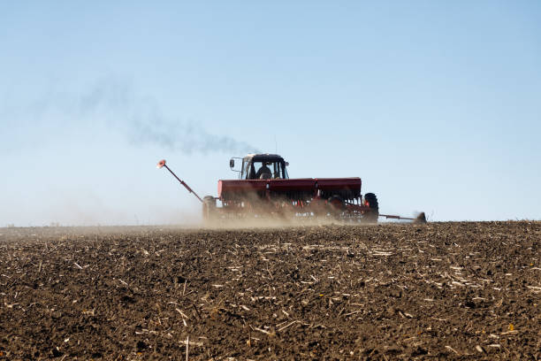 istock Tractor with a seeder on the field 1135409267