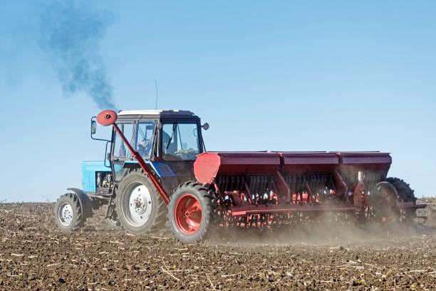 istock Tractor with a seeder on the field 1135409377