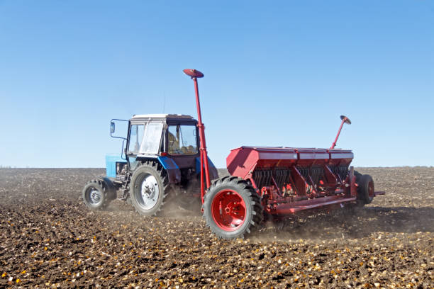 istock Tractor with a seeder on the field 1135409396