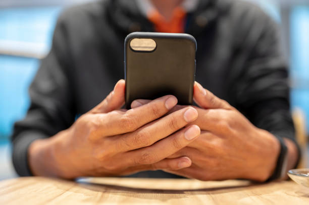 istock Men hold a black mobile phone at the desk. 1135411970