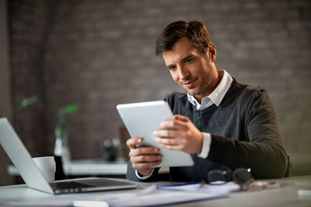 istock Happy businessman working on touchpad while being in the office. 1135415076