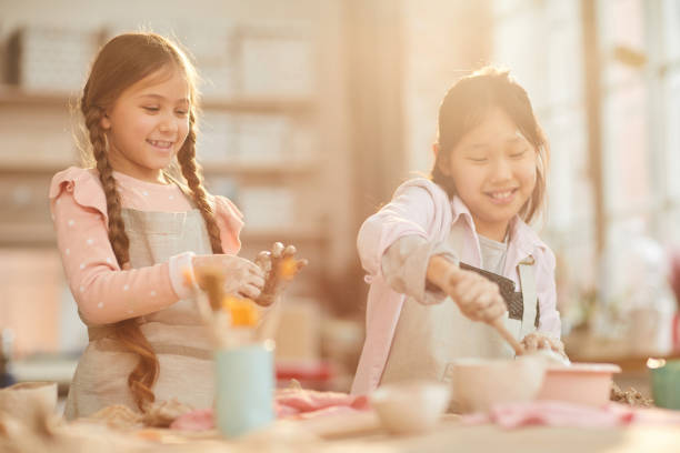 istock Cute Little Girls in Pottery Workshop 1135415964