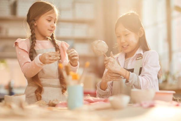 istock Cute Little Girls in Pottery Class 1135415965
