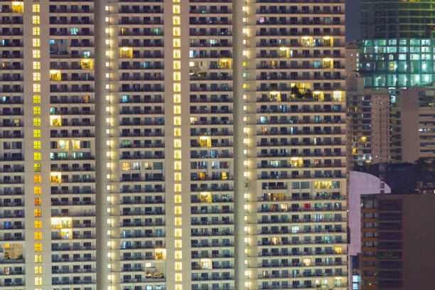 istock Tall residential highrise with apartment windows lit at night 1135431164