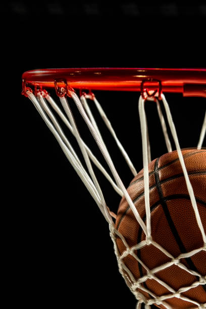 istock Looking up at a basketball falling through the net in motion blur with a black background 1135431794