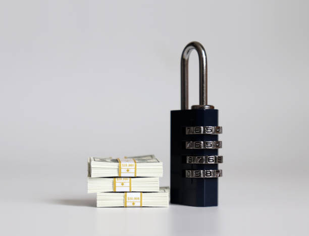 istock A combination lock and bundle of hundred dollar bills. 1135434208