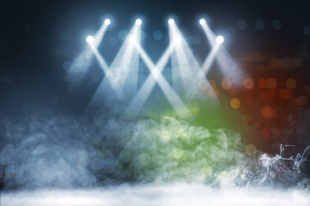 Empty performance stage illuminated by bright spotlights, with no people. Red and blue shining lights with dark surroundings and some smoke. Theatre or music venue scene with stage's edge visible and copy space. Digitally generated image.