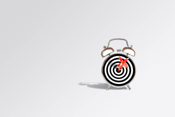 istock Time Management Concept : Red dart hit target on dartboard and alarm clock. 1135447310